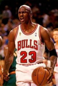 Michael Jordan ceebrando una jugada con a la camiseta de los Bulls de color blanca